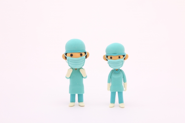 手術用ガウンを着た2人の紙粘土人形の医師の写真
